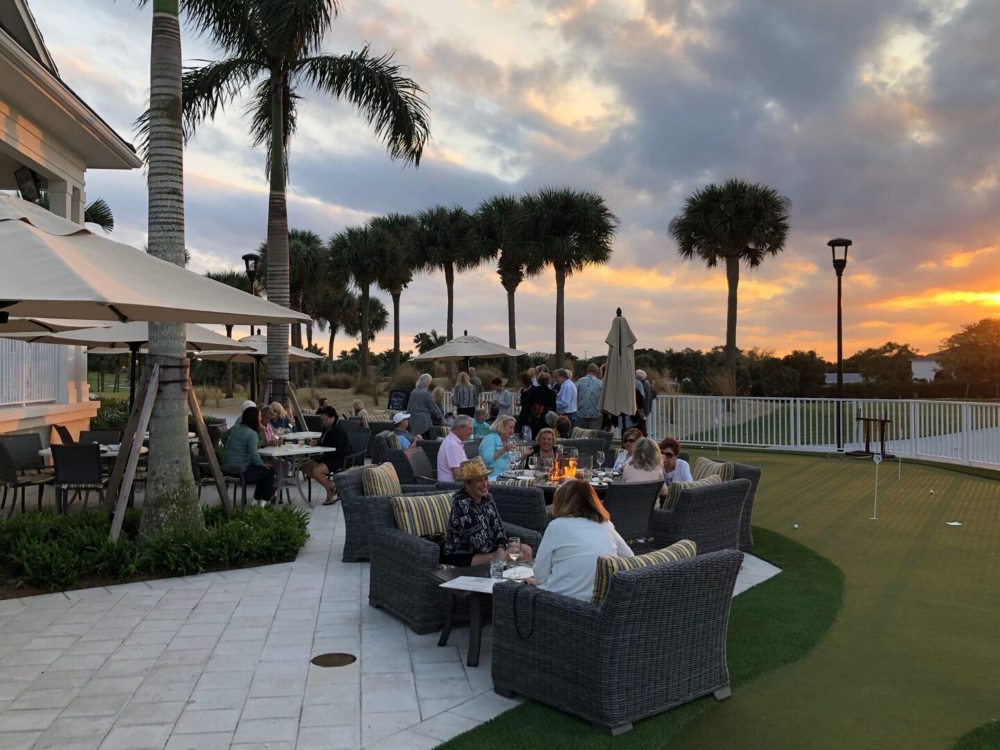 A group of people sitting around on patio furniture.