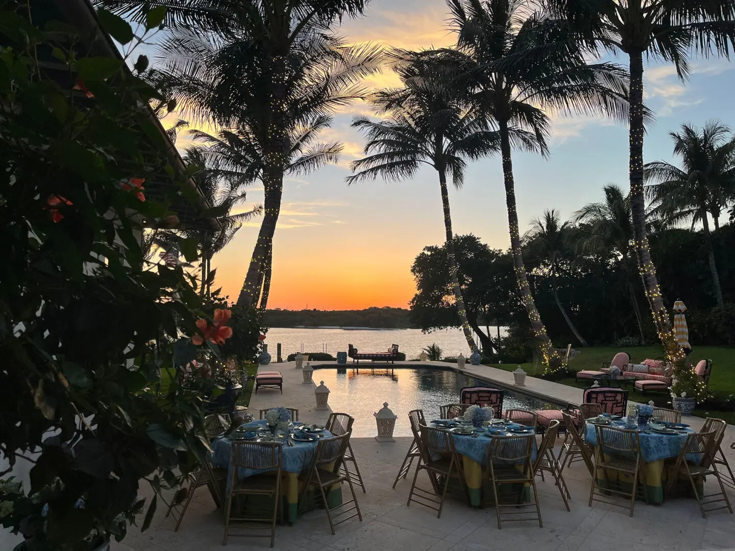 A group of tables and chairs in front of the water.