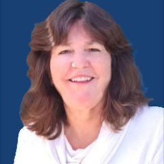 A woman with brown hair and white shirt smiling.